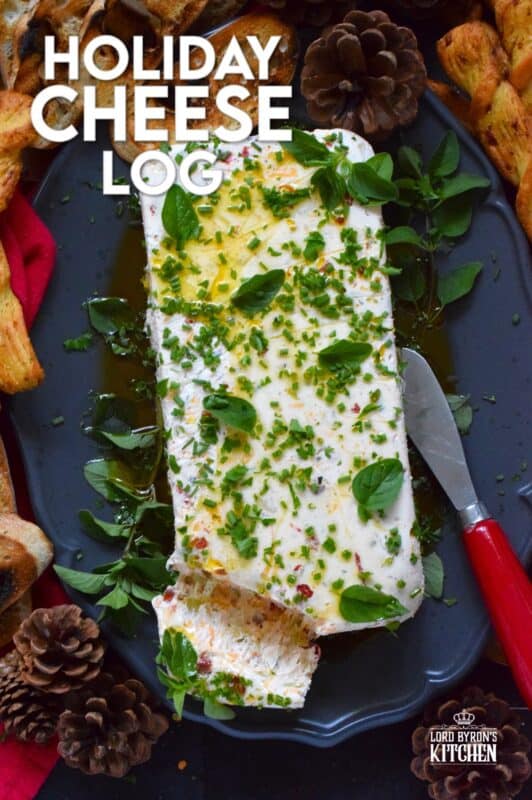 This Holiday Cheese Log is packed with a tonne of flavourful add-ins, such as chili flakes, roasted red peppers, sun-dried tomatoes, and fresh chives. Seasoned with garlic, onion, basil, oregano, and more, this holiday appetizer is a tremendously delicious party favourite! #cheeselog #appetizer #holiday #christmas