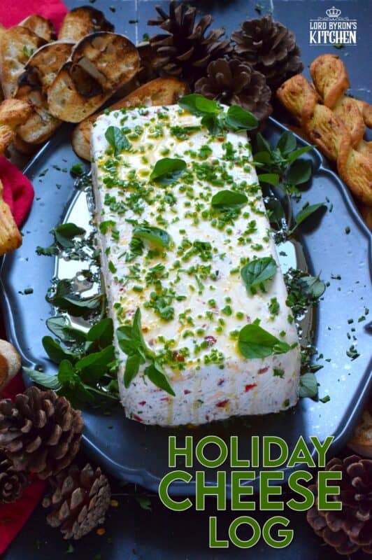This Holiday Cheese Log is packed with a tonne of flavourful add-ins, such as chili flakes, roasted red peppers, sun-dried tomatoes, and fresh chives. Seasoned with garlic, onion, basil, oregano, and more, this holiday appetizer is a tremendously delicious party favourite! #cheeselog #appetizer #holiday #christmas