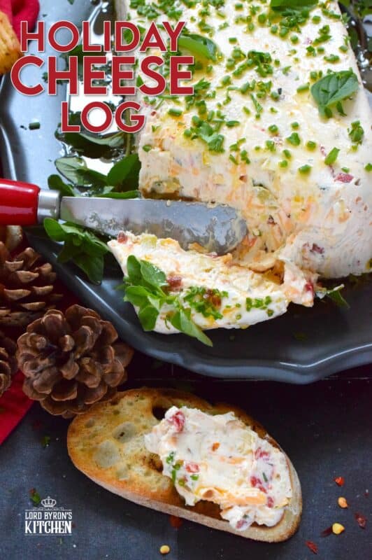 This Holiday Cheese Log is packed with a tonne of flavourful add-ins, such as chili flakes, roasted red peppers, sun-dried tomatoes, and fresh chives. Seasoned with garlic, onion, basil, oregano, and more, this holiday appetizer is a tremendously delicious party favourite! #cheeselog #appetizer #holiday #christmas