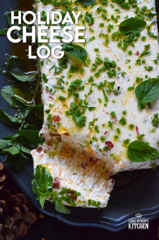 This Holiday Cheese Log is packed with a tonne of flavourful add-ins, such as chili flakes, roasted red peppers, sun-dried tomatoes, and fresh chives. Seasoned with garlic, onion, basil, oregano, and more, this holiday appetizer is a tremendously delicious party favourite! #cheeselog #appetizer #holiday #christmas