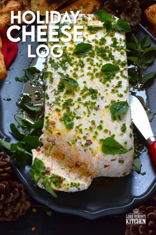 This Holiday Cheese Log is packed with a tonne of flavourful add-ins, such as chili flakes, roasted red peppers, sun-dried tomatoes, and fresh chives. Seasoned with garlic, onion, basil, oregano, and more, this holiday appetizer is a tremendously delicious party favourite! #cheeselog #appetizer #holiday #christmas