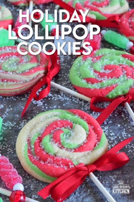 Add colour and pizzazz to your holiday cookie platter with these Holiday Lollipop Cookies! Spiralled and rolled cookie dough is topped with sparkling sugar and baked with a stick. These are sure to produce lots of smiles and crown you the winner of holiday baking! #lollipop #cookies #christmas