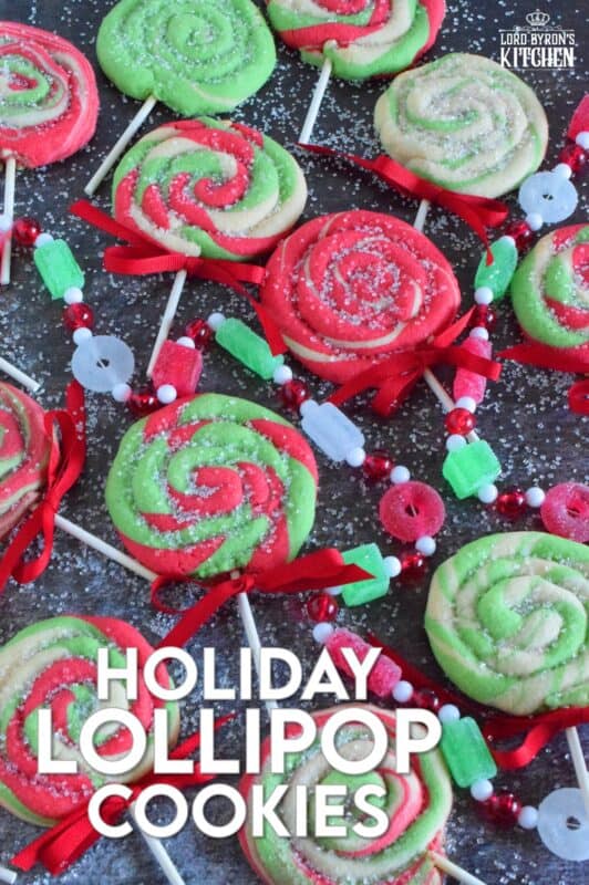 Add colour and pizzazz to your holiday cookie platter with these Holiday Lollipop Cookies! Spiralled and rolled cookie dough is topped with sparkling sugar and baked with a stick. These are sure to produce lots of smiles and crown you the winner of holiday baking! #lollipop #cookies #christmas