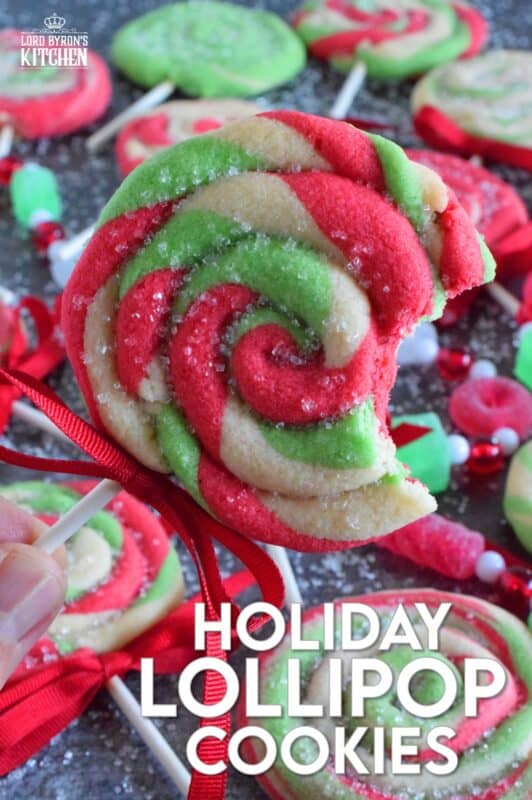 Add colour and pizzazz to your holiday cookie platter with these Holiday Lollipop Cookies! Spiralled and rolled cookie dough is topped with sparkling sugar and baked with a stick. These are sure to produce lots of smiles and crown you the winner of holiday baking! #lollipop #cookies #christmas
