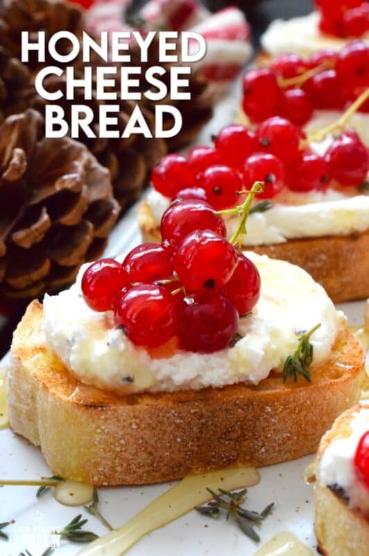 Toast or grill thinly sliced bread and top it with whipped goat cheese. Drizzle over your favourite honey and garnish with fresh thyme leaves and berries. Honeyed Cheese Bread is sweet and salty and is completely irresistible. The creaminess of the cheese and honey is a great match for the chewiness of the toasted baguette. #honey #bread #appetizer #christmas #holiday