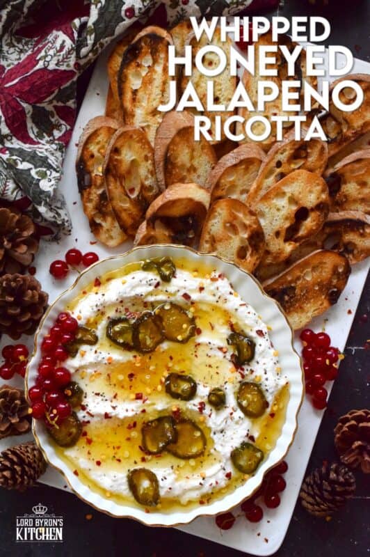 When you whip ricotta with garlic, onion, oregano, and sour cream, not only is the flavour incredible, but the texture is silky smooth. Topped with homemade Jalapeno Honey, this dip is cool and spicy at the same time. Serve with your favourite crackers and bread. #ricotta #appetizer #spread #dip #cheese #honey #jalapeno
