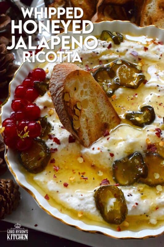 When you whip ricotta with garlic, onion, oregano, and sour cream, not only is the flavour incredible, but the texture is silky smooth. Topped with homemade Jalapeno Honey, this dip is cool and spicy at the same time. Serve with your favourite crackers and bread. #ricotta #appetizer #spread #dip #cheese #honey #jalapeno
