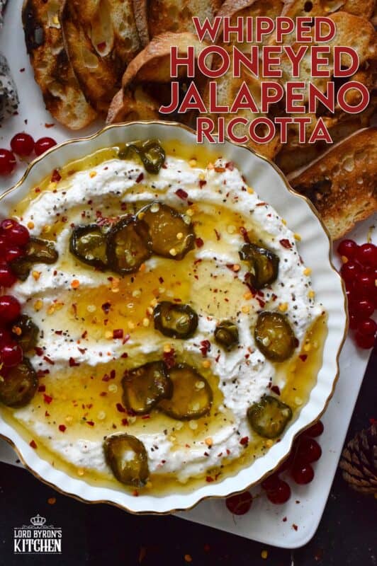 When you whip ricotta with garlic, onion, oregano, and sour cream, not only is the flavour incredible, but the texture is silky smooth. Topped with homemade Jalapeno Honey, this dip is cool and spicy at the same time. Serve with your favourite crackers and bread. #ricotta #appetizer #spread #dip #cheese #honey #jalapeno