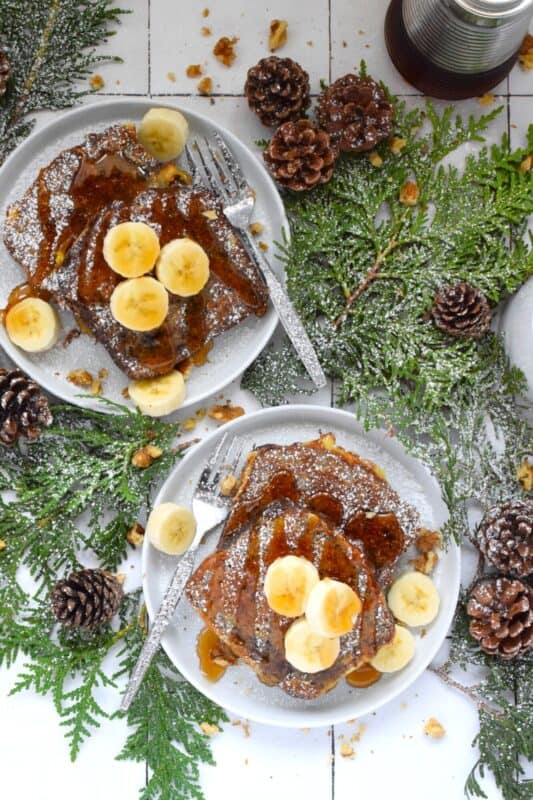 Soaked in an egg custard with familiar holiday spices like cinnamon, nutmeg, ginger, and cloves, Banana Bread French Toast is one of the most indulgent, richest, and most comforting foods you'll eat this entire Christmas season! Topped with warm maple syrup, whipped cream and toasted walnuts, it really doesn't get any better! #banana #bread #french #toast #breakfast #christmas