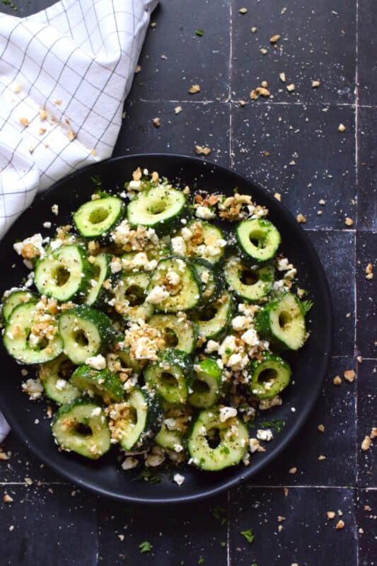 A great side or a refreshing snack, Sweet and Salty Cucumber Rings are the result of summer fresh cucumbers being paired with toasted pecans, crumbled feta, and lots of drizzled honey. Serve at room temperature immediately after preparing for the best results! #cucumber #sweetandsalty #salad #snack #feta