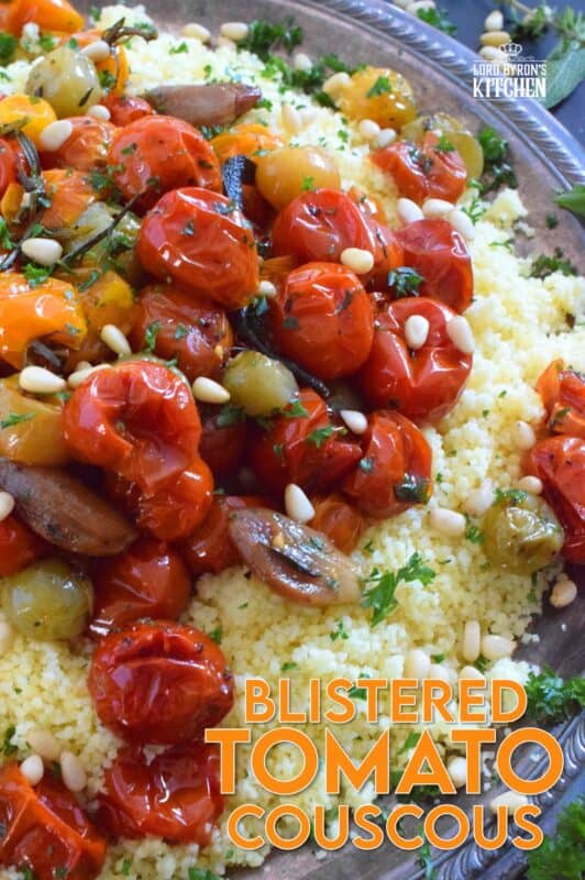 Summer fresh cherry tomatoes are slowly roasted with garlic, onions, and herbs in olive oil until the skins have blistered. Spoon over cooked couscous and sprinkle with pinenuts for a delicous, comforting, and filling main or side! #couscous #confit #tomato #roasted