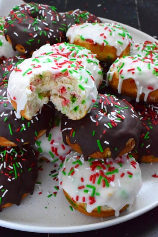 For the kid in all of us this holiday season let's make some Funfetti Christmas Donuts! This light and fluffy vanilla donut is filled with sprinkles and topped with a sugary, sweet glaze. Better than store-bought, these donuts make a lovely bring-along party treat as well! #funfetti #sprinkles #christmas #donuts #doughnuts