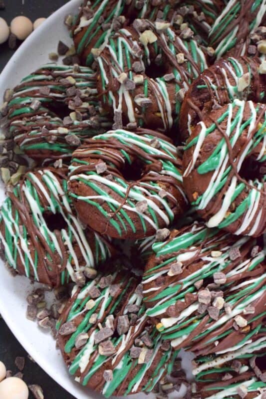 These donuts are loaded with mint flavour and are meant for serious mint and chocolate lovers. Andes Mint Chocolate Donuts are baked with good cocoa, mint extract, and mint chocolate, and topped with green candy melts and melted white and milk chocolate. It was so hard to eat just one of these! #andesmints #chocolates #donuts