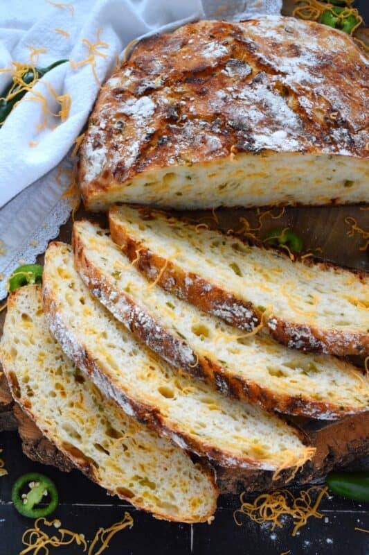 There’s something really soothing and satisfying about freshly baked bread. Even more so when you bake that bread yourself! No Knead Jalapeno Cheddar Bread is one of the most delicious and easiest breads you'll ever make! Loaded with freshly chopped jalapenos and grated cheese, this bread is cheesy and moderately spicy - perfect to dip into soup! #bread #dutchoven #jalapeno #cheddar #artisan #homemade