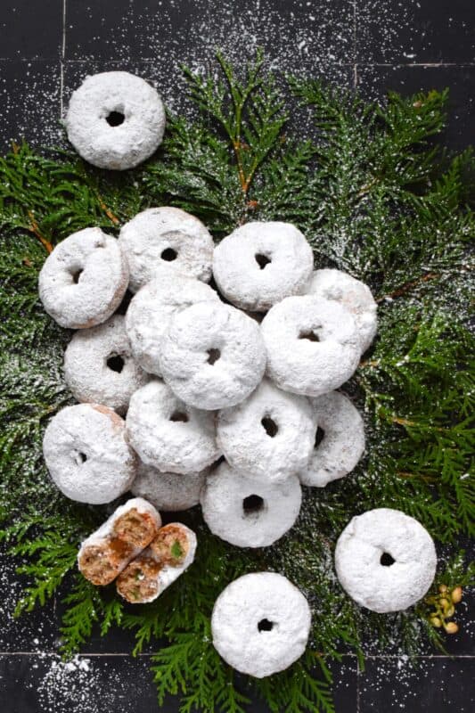 Packed full of red and green candied cherries and chopped toasted walnuts, these Walnut Cherry Donuts are the epitome of holiday-themed donuts! Baked with familiar Christmas spices, this donut is very similar in flavour to fruitcake - but without the fuss! #walnut #candied #cherries #donuts