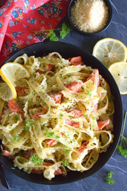 Salmon fillets are lightly seasoned and fried in butter until they are perfectly done. The salmon is gently flaked into bite-sized pieces and tossed with cooked pasta, lemon juice and zest, and lots of garlic. Fried Salmon Pasta is a beautiful and delicious main which takes less than 30 minutes from start to finish! #salmon #pasta #seafood #spaghetti #lemongarlic