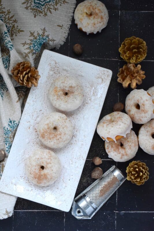 These Glazed Eggnog Donuts are baked and not fried, which means they are super light and fluffy. Eggnog is baked right into the batter and the glaze is made with eggnog too, ensuring that this donut lives up to its name! Optionally, this recipe permits a splash or rum or an alcohol-free version too! #donuts #doughnuts #eggnog #christmas #baked