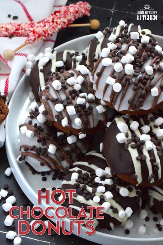 Good cocoa is the secret to a decadent hot chocolate; the same can be said for these Hot Chocolate Donuts.  Marshmallows are baked into the chocolate donut and sprinkled on top of the white glaze and the chocolate drizzle.  These baked donuts are for the ultimate chocolate lover! #hotchocolate #donuts #marshmallows