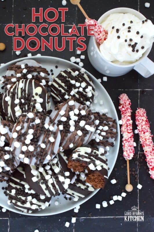 Good cocoa is the secret to a decadent hot chocolate; the same can be said for these Hot Chocolate Donuts.  Marshmallows are baked into the chocolate donut and sprinkled on top of the white glaze and the chocolate drizzle.  These baked donuts are for the ultimate chocolate lover! #hotchocolate #donuts #marshmallows