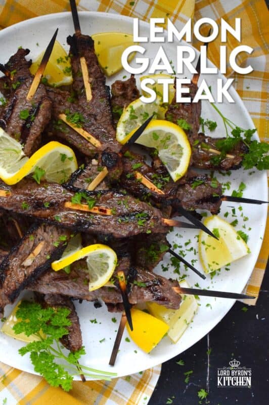 Thin slices of beef are marinated with fresh lemon juice, chopped garlic, and seasonings before being skewered and grilled to perfection!  Be sure to serve this Lemon Garlic Steak with lots of fresh lemons for extra zip and zing! #steak #grilled #garlic #lemon