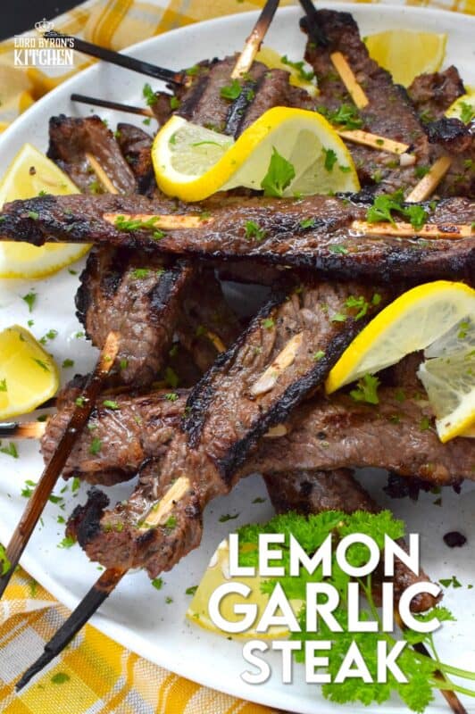 Thin slices of beef are marinated with fresh lemon juice, chopped garlic, and seasonings before being skewered and grilled to perfection!  Be sure to serve this Lemon Garlic Steak with lots of fresh lemons for extra zip and zing! #steak #grilled #garlic #lemon
