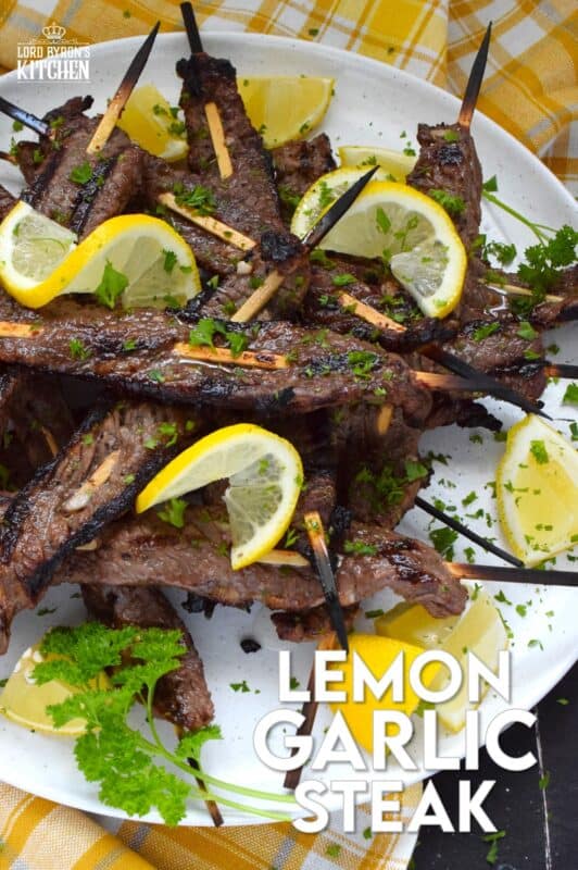 Thin slices of beef are marinated with fresh lemon juice, chopped garlic, and seasonings before being skewered and grilled to perfection!  Be sure to serve this Lemon Garlic Steak with lots of fresh lemons for extra zip and zing! #steak #grilled #garlic #lemon