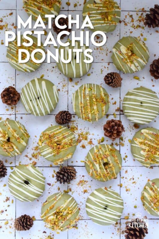 Everything is coming up green in these Matcha Pistachio Donuts! The batter is light and fluffy and prepared with finely chopped pistachios and matcha. Dipped in matcha-infused icing and drizzled with white chocolate, these donuts are delicious and addictive! #matcha #greentea #donuts #pistachio