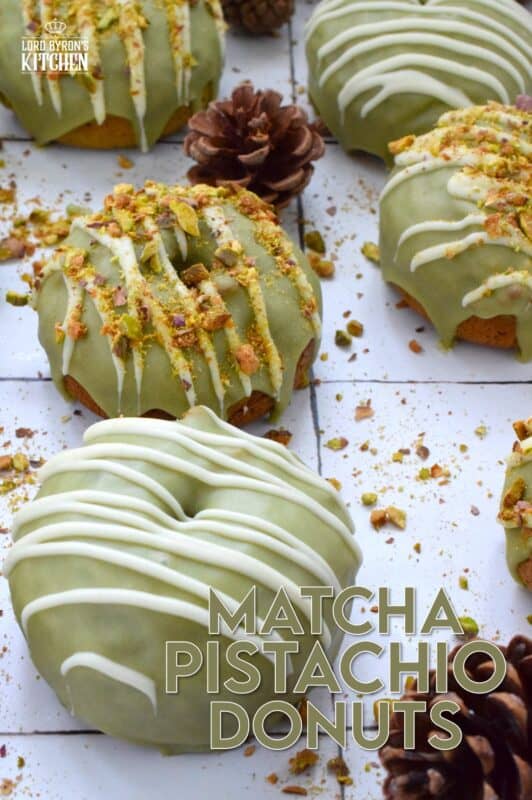 Everything is coming up green in these Matcha Pistachio Donuts! The batter is light and fluffy and prepared with finely chopped pistachios and matcha. Dipped in matcha-infused icing and drizzled with white chocolate, these donuts are delicious and addictive! #matcha #greentea #donuts #pistachio