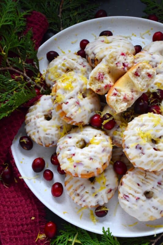 The tartness of lemon and cranberries is well balanced with sugary sweetness in these delightfully refreshing Lemon Cranberry Donuts! Prepared with freshly squeezed lemon juice and lemon zest, chopped cranberries, and a lemony glaze, these donuts are simply irresistible! #lemon #cranberry #donuts