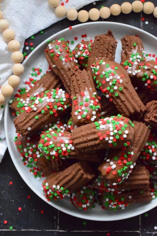 Buttery and chocolatey, Piped Hot Cocoa Cookies are delicious just as they are, but they're even better dipped in silky smooth melted milk chocolate! Not only are these fun to make, but everyone loves them! Be sure to include these tasty little treats on your holiday dessert table this year! #chocolate #cocoa #hotcocoa #cookies