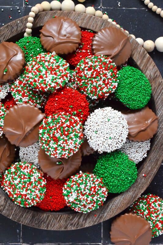 Prepared with good baking cocoa, these Mocha Nonpareil Cookies are dipped in melted milk chocolate and covered with everyone's favourite sprinkles! The cookies are firm and crisp, but they melt in your mouth. Baked with a splash of coffee extract, everyone will be trying to guess why these cookies taste so good! #nonpareil #sprinkles #cookies #christmas #chocoalte #dipped