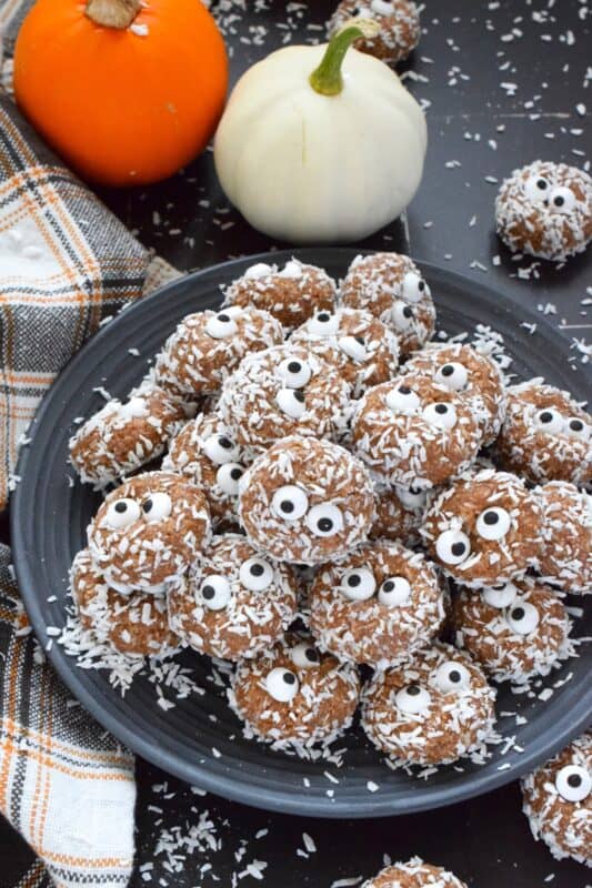 Prepared with melted marshmallows, cocoa powder, sweetened condensed milk, and graham cracker crumbs, No Bake Monster Cookies are sure to give you autumn smores vibes. The addition of the googly candy eyes in the center of each cookie helps make these cookies feel and look perfectly ready for Halloween! #halloween #monster #nobake #cookies #balls