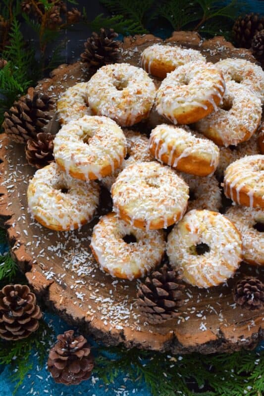 In our home, Christmas would not be Christmas without a confection prepared with coconut and these Toasted Coconut Donuts hit the mark! These are baked and not fried so they are super light! Imagine an old-fashioned glazed donut but with the addition of nutty, crispy toasted coconut - yum! #toasted #coconut #donuts