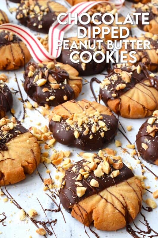In our home, you cannot go wrong with the classic combination of peanut butter and chocolate! These delicious Chocolate Dipped Peanut Butter Cookies are dipped in melted chocolate and topped with a sprinkling of chopped salted peanuts. These are so easy to make, so whip up several batches and gift them to your friends, neighbours, and coworkers! #peanutbutter #cookies #chocolate #christmas #holiday #baking