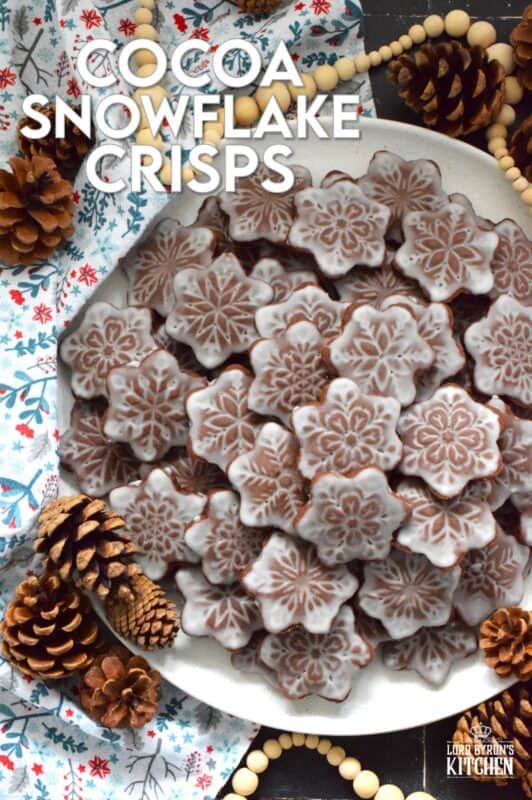 These thin and crispy chocolate cookies are a perfect holiday treat! Cocoa Snowflake Crisps are made with good cocoa and salted butter which help to make them super chocolatey and buttery with a snap-crisp texture. Top them with a thin sugary glaze to make them extra tasty and super festive too! #cocoa #chocolate #snowflake #cookies