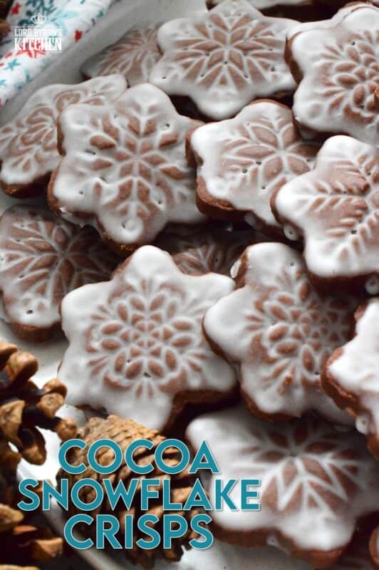 These thin and crispy chocolate cookies are a perfect holiday treat! Cocoa Snowflake Crisps are made with good cocoa and salted butter which help to make them super chocolatey and buttery with a snap-crisp texture. Top them with a thin sugary glaze to make them extra tasty and super festive too! #cocoa #chocolate #snowflake #cookies