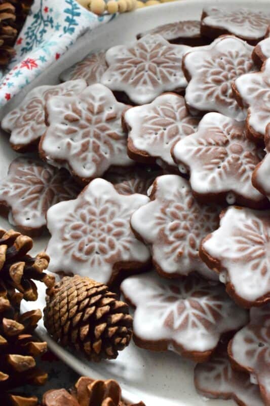 These thin and crispy chocolate cookies are a perfect holiday treat! Cocoa Snowflake Crisps are made with good cocoa and salted butter which help to make them super chocolatey and buttery with a snap-crisp texture. Top them with a thin sugary glaze to make them extra tasty and super festive too! #cocoa #chocolate #snowflake #cookies