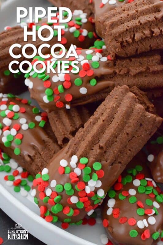 Buttery and chocolatey, Piped Hot Cocoa Cookies are delicious just as they are, but they're even better dipped in silky smooth melted milk chocolate! Not only are these fun to make, but everyone loves them! Be sure to include these tasty little treats on your holiday dessert table this year! #chocolate #cocoa #hotcocoa #cookies