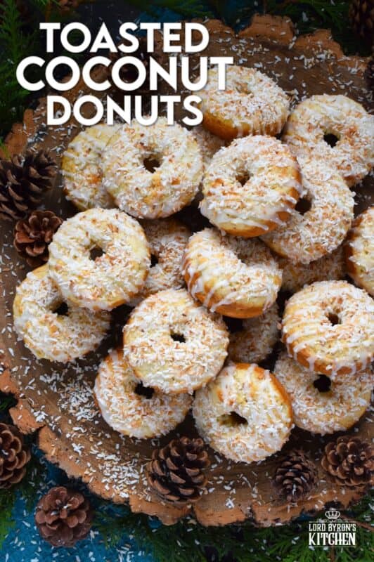 In our home, Christmas would not be Christmas without a confection prepared with coconut and these Toasted Coconut Donuts hit the mark! These are baked and not fried so they are super light! Imagine an old-fashioned glazed donut but with the addition of nutty, crispy toasted coconut - yum! #toasted #coconut #donuts