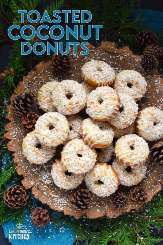 In our home, Christmas would not be Christmas without a confection prepared with coconut and these Toasted Coconut Donuts hit the mark! These are baked and not fried so they are super light! Imagine an old-fashioned glazed donut but with the addition of nutty, crispy toasted coconut - yum! #toasted #coconut #donuts