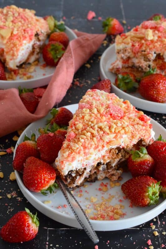 A no-bake dessert that is best prepared in advance and refrigerated overnight, this delicious Layered Strawberry Shortcake Dessert uses homemade strawberry shortcake crumbs, chocolate chip cookies, and a cream cheese-based cream topping. Serve with fresh strawberries! #strawberry #shortcake #dessert #layered #cookies #creamcheese