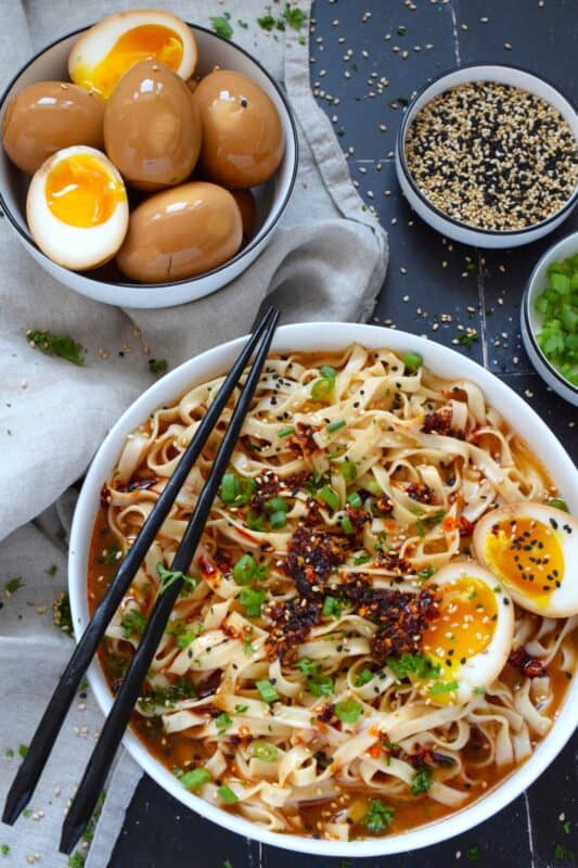 The perfect addition to any piping hot bowl of ramen or spicy noodles, Marinated Soft Boiled Eggs add flavour and texture. The velvety consistency of that golden yellow yolk offers a touch of creaminess and smoothness to soups and noodles. Try chopping a couple of these eggs over steamed rice too! #marinated #asian #softboiled #eggs #soyeggs #korean
