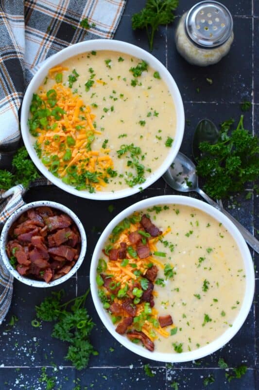 Creamy and smooth, this Baked Potato Soup is prepared with onion and garlic in a simple roux which is what makes the soup thick and lucious. Add cheese and crumbled cooked bacon for even more texture and flavour! Serve with warm, crusty bread for a complete, hearty meal! #bakedpotato #creamy #soup #cheesy #potatoes