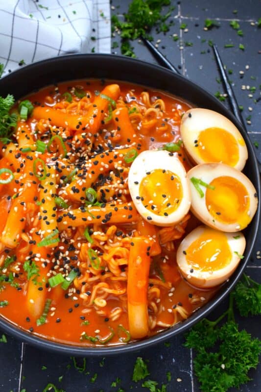 Most commonly referred to as robokki in Korea, this dish combines the chewy texture of tteokbokki, or rice cakes, with the delicious spiciness of your favourite Korean noodles. Served with marinated soft boiled eggs, and topped with fresh green onions and toasted sesame seeds, this is the ultimate ramen noodle feast! #tteokbokki #korean #ricecakes #robokki