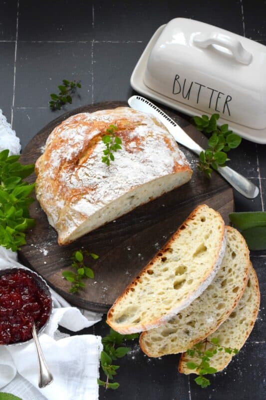 Freshly baked homemade bread is the ultimate comfort food.  There really is nothing like it!  Artisan Garlic and Herb Bread is one of the most delicious and easiest breads you’ll ever make! Loaded with fresh chopped garlic and herbs, this bread is quite aromatic and very savoury! #bread #noknead #dutchoven #homemade #garlic #herbs