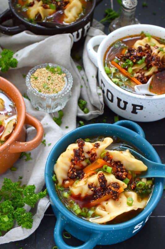 Pick up a package of frozen potstickers, wontons, or dumplings from your local grocery store and cook them in a savoury broth to make the most deliciously wonderful Spicy Potsticker Soup. Loaded with green onions, garlic, ginger, and carrots, this soup is good for you too! #spicy #potsticker #wonton #gyoza #stew #soup #chili #chilicrunch