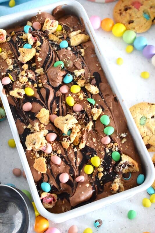 Developed with the chocolate mini egg enthusiast in mind, this no churn ice cream is so quick and easy to prepare! Smooth and velvety, flavoured and enriched with good cocoa, this ice cream is loaded with Cadbury Easter chocolate eggs, crumbled chocolate cookies, and even a chocolate syrup drizzle! #nochurn #icecream #minieggs #easter #cadbury