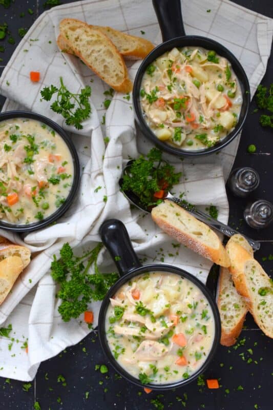 Chicken Pot Pie Soup is the ultimate comfort food. It's so easy to prepare and it's tremendously delicious! Sauteed onions, peas, carrots, garlic, and baked potatoes are smothered in a homemade creamy soup base with a generous amount of shredded cooked chicken. Serve this soup on its own or with some good crusty bread! #chicken #rotisserie #potpie #soup