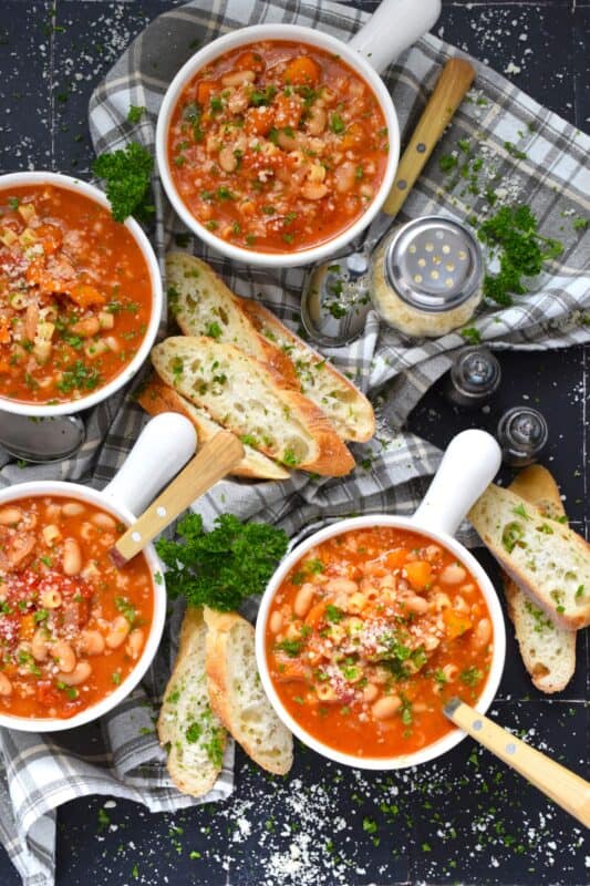 One of the most warming and cozy soups, Pasta Fagioli Soup is prepared with canned cannellini beans, canned tomato sauce, store-bought vegetable stock, dried herbs and seasonings, and a box of pasta. Needless to say, most of the ingredients just might be in your pantry already! About 30 minutes from start to finish is all you need! #soup #pasta #fagioli #vegetarian #beans