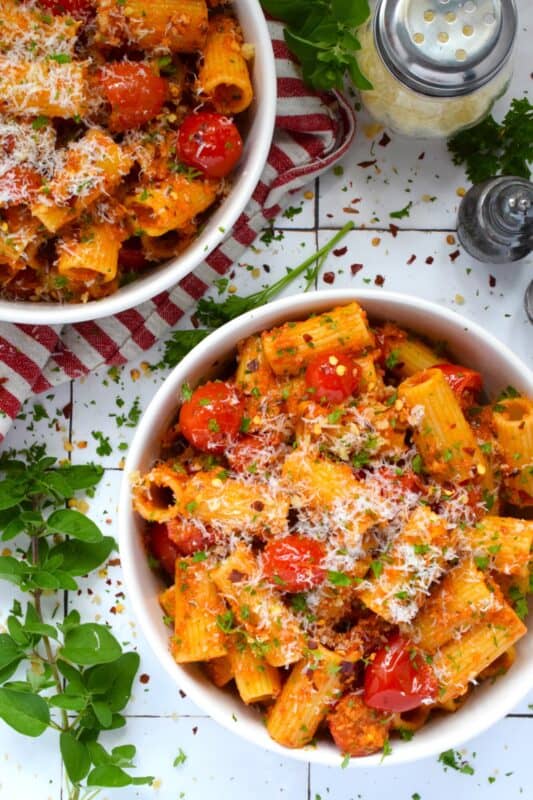 Quick, easy, and delicious describes this Tomato and Fresh Herb Rigatoni! Use fresh cherry tomatoes, thyme and oregano leaves with fresh parsley to make this pasta extra special. The sauce is prepared by blistering the tomatoes in garlic and oil before tossing it with pesto.  Perfect for a weeknight family dinner, this dish takes about 30 minutes from start to finish and you get to dig in and enjoy! #pasta #herbs #fresh #tomato #30minutemeals #familymeals